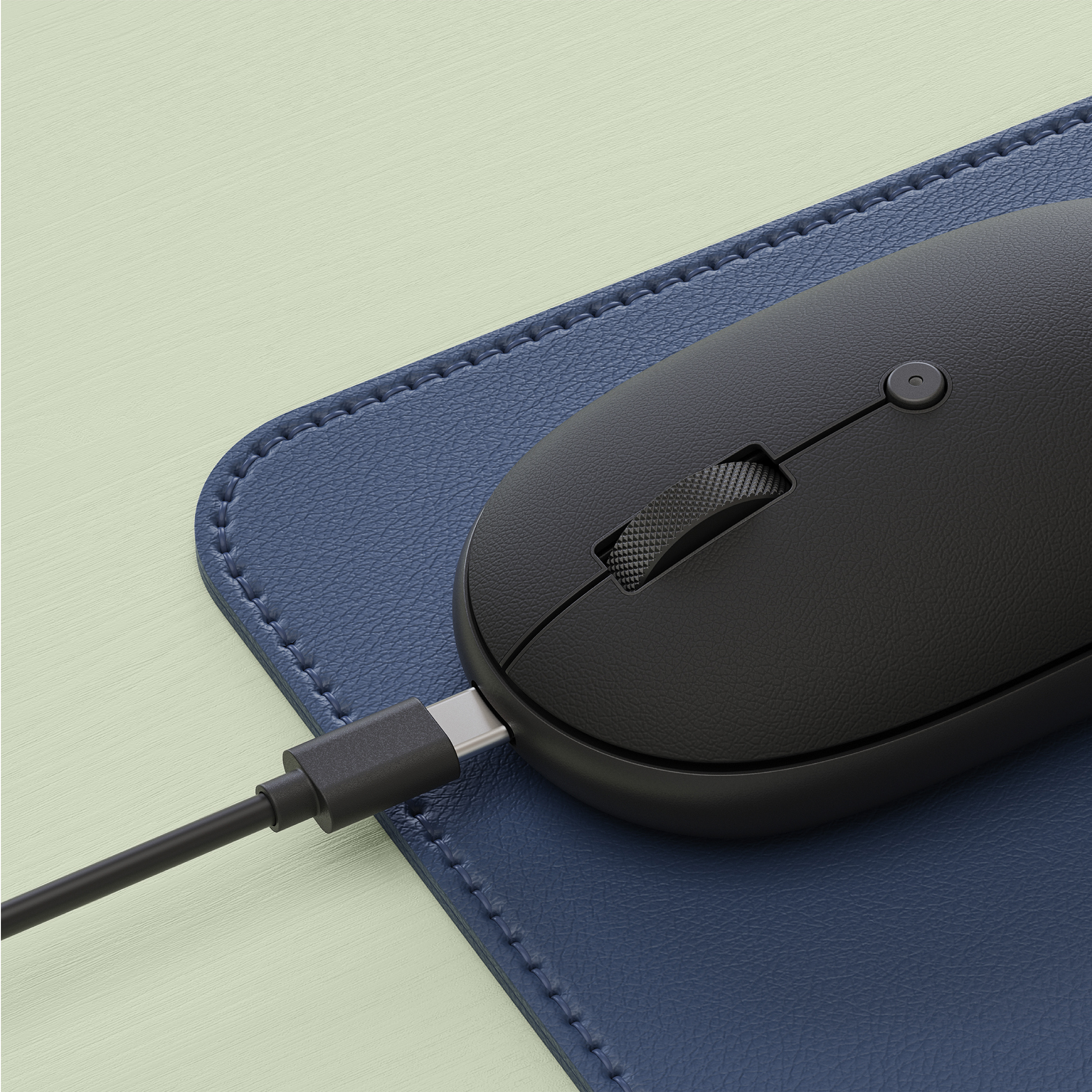 Mouse nero con cavo USB-C su tappetino blu scuro.