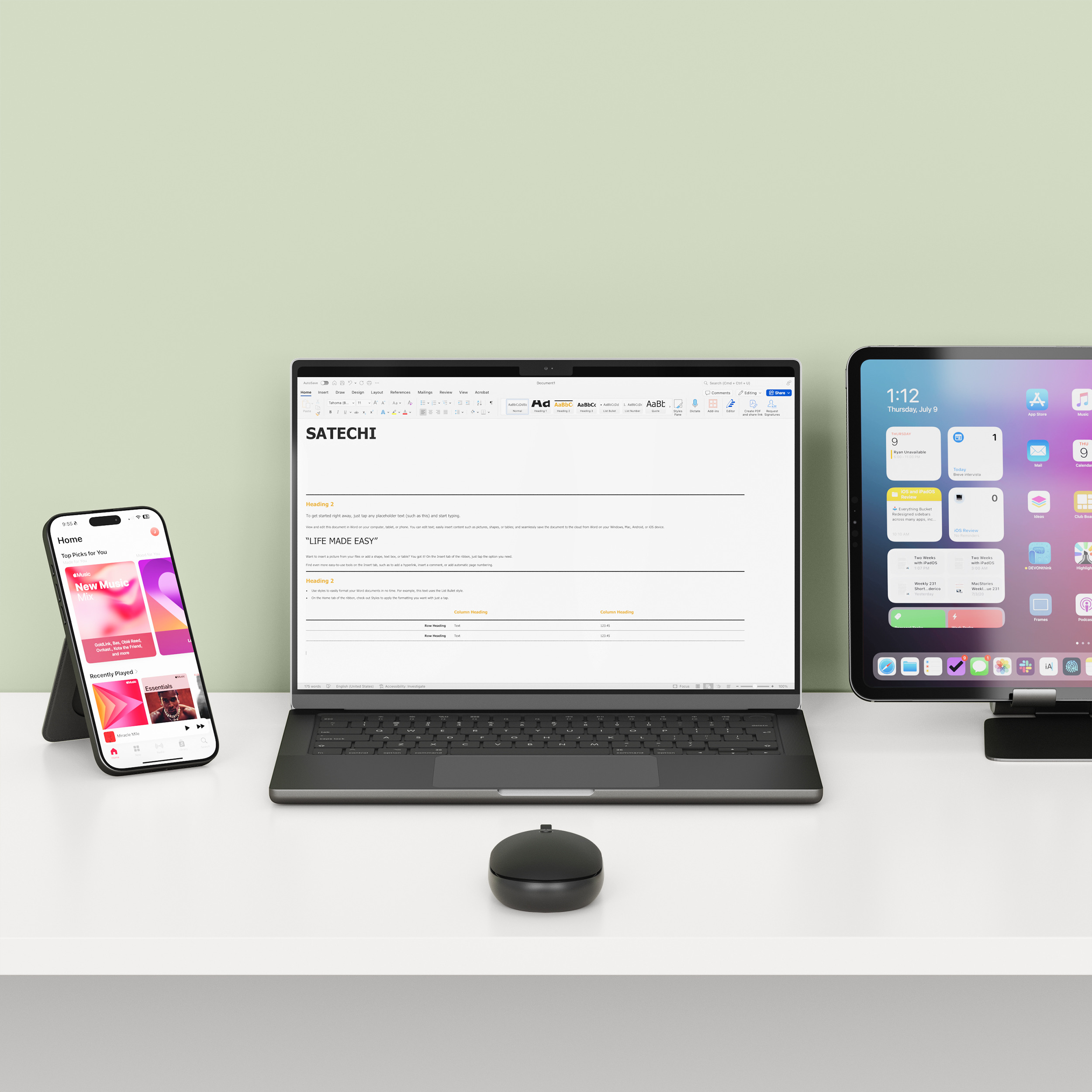 Un laptop, uno smartphone e un tablet sono uno accanto all'altro su una scrivania.