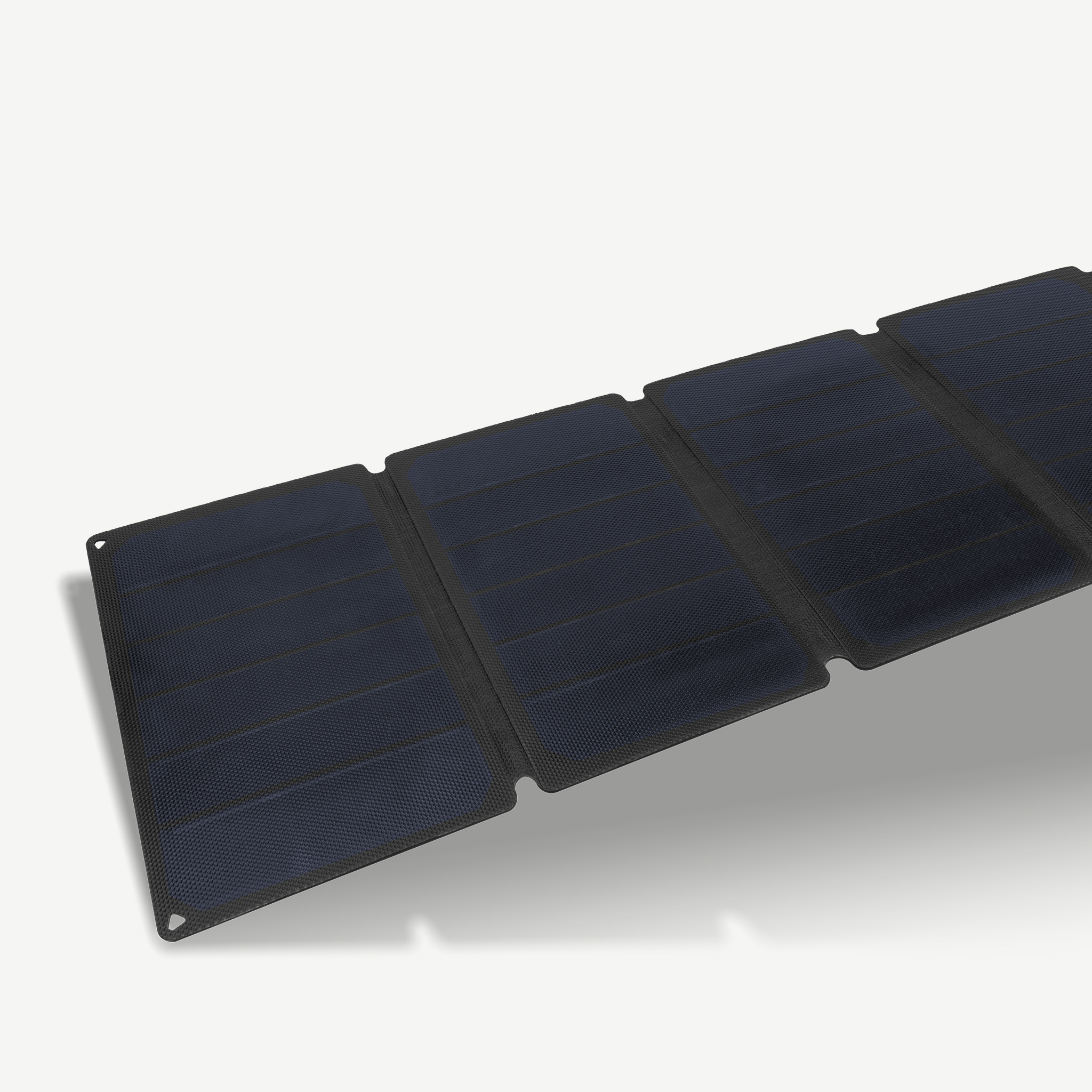 Ein faltbares Solarpanel mit dunklen Zellen und schwarzem Rahmen, auf hellem Untergrund.