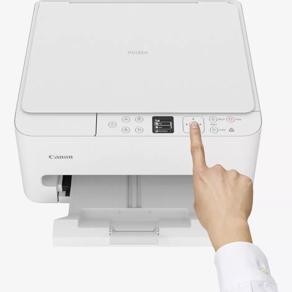 Una mano preme la freccia su una stampante Canon Pixma bianca.