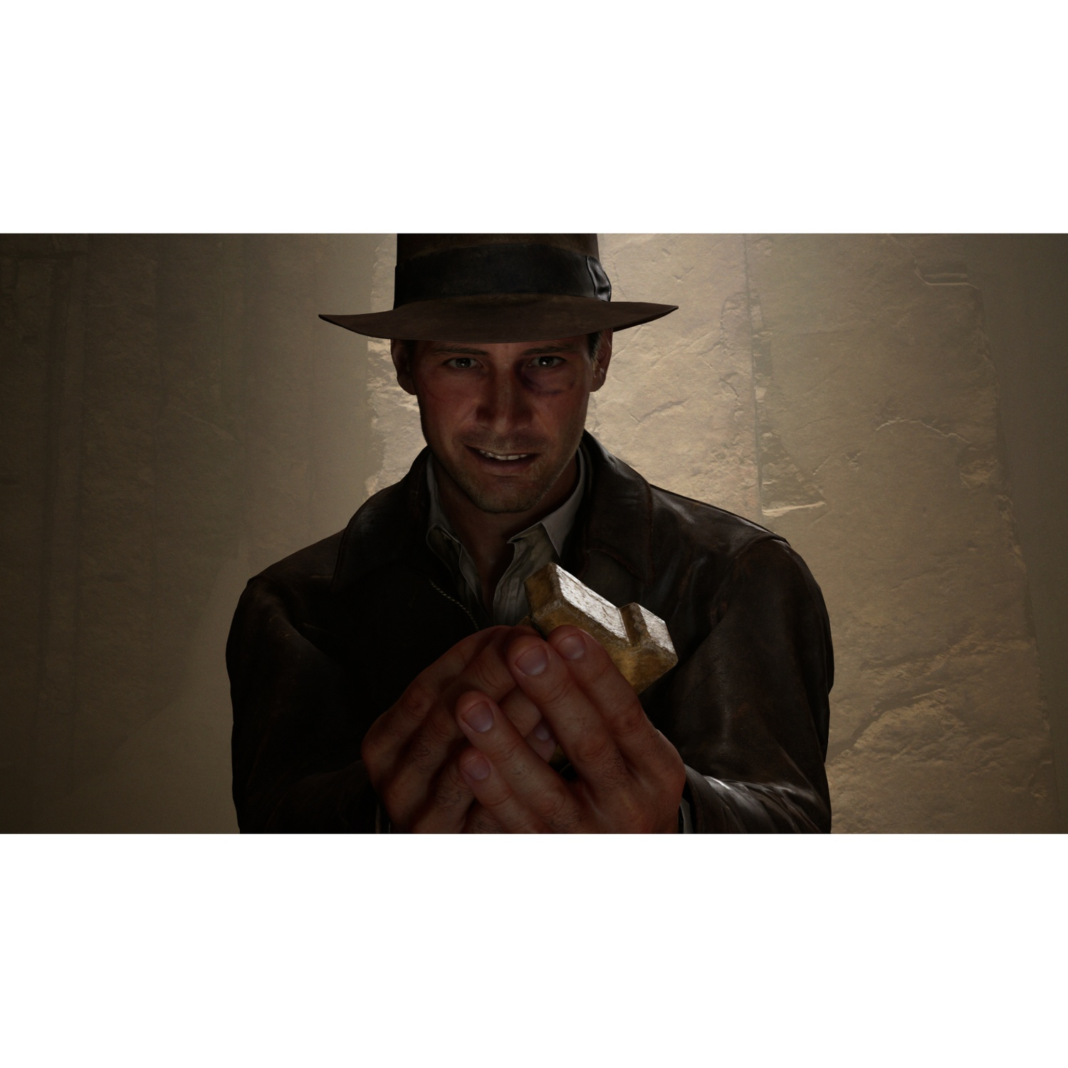 Un homme en chapeau et veste en cuir tient un artefact doré.