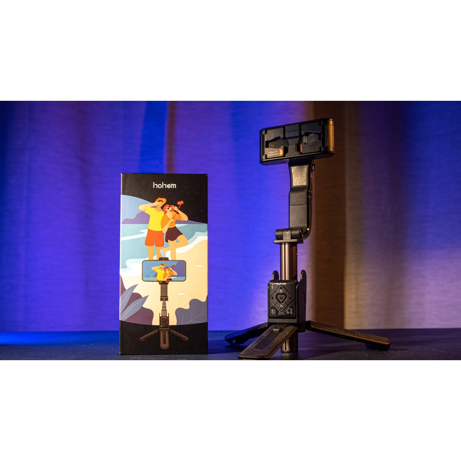Un treppiede per fotocamera nero con supporto per telefono e una scatola con immagini.