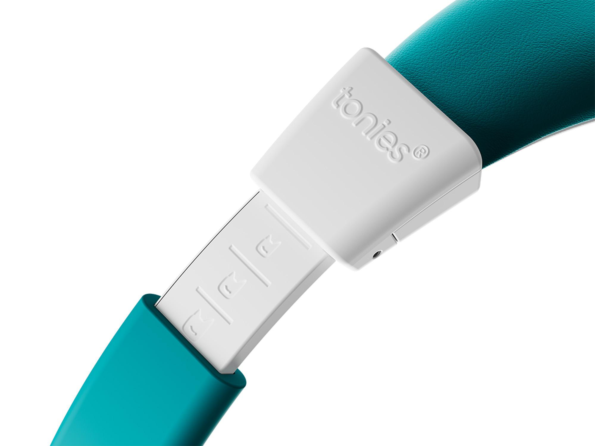 Ein weißer Stecker mit der Aufschrift „tonies®“ ist mit einem türkisfarbenen Band verbunden.
