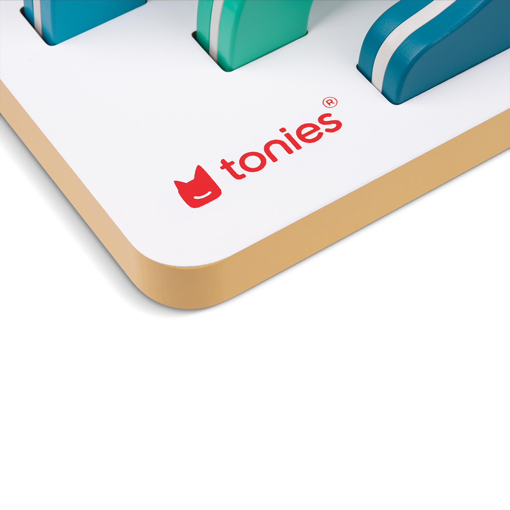 Nahaufnahme eines weißen Bretts mit Tonies-Logo und blauen und grünen Figuren.