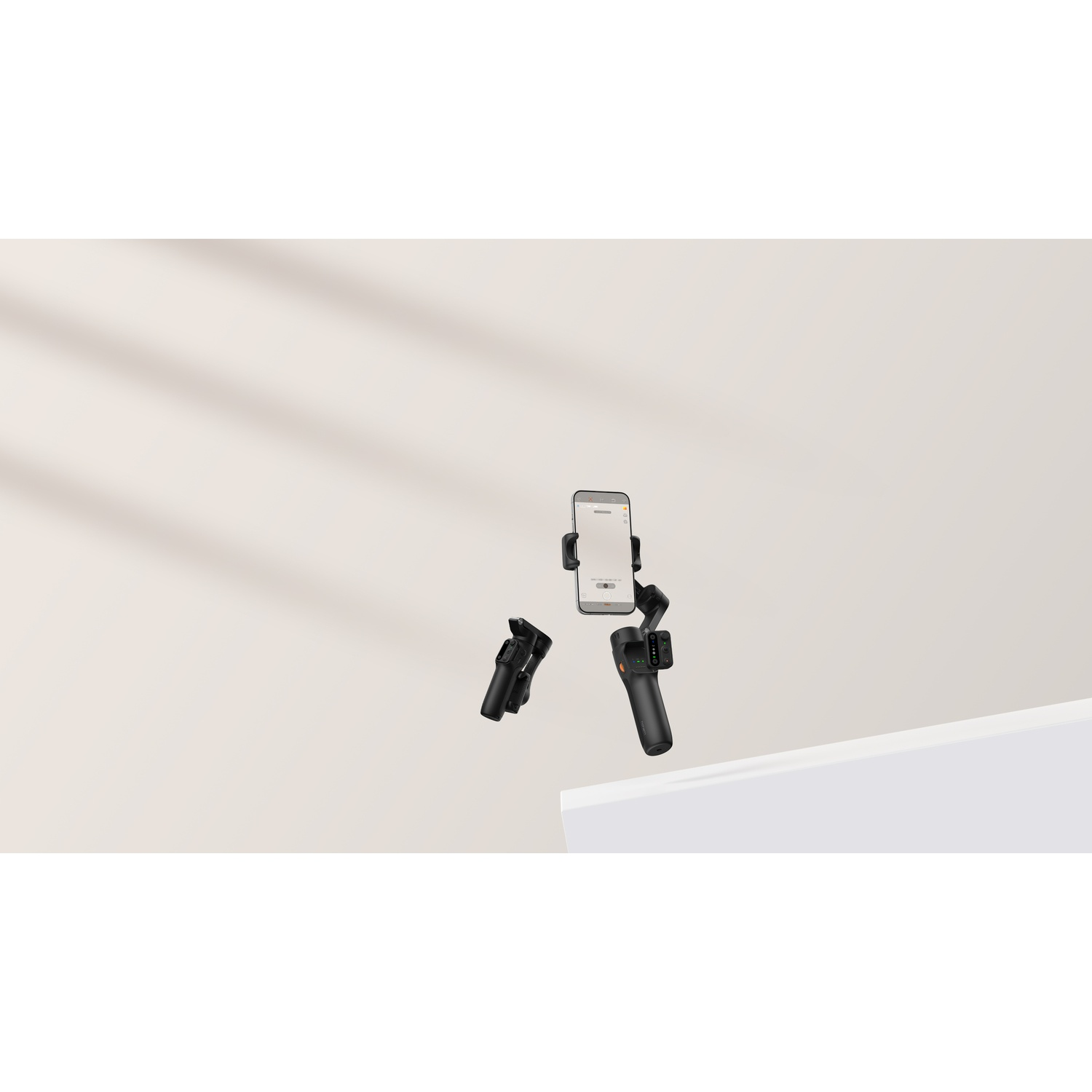 Gimbal nero per smartphone con accessori su sfondo chiaro con ombre.