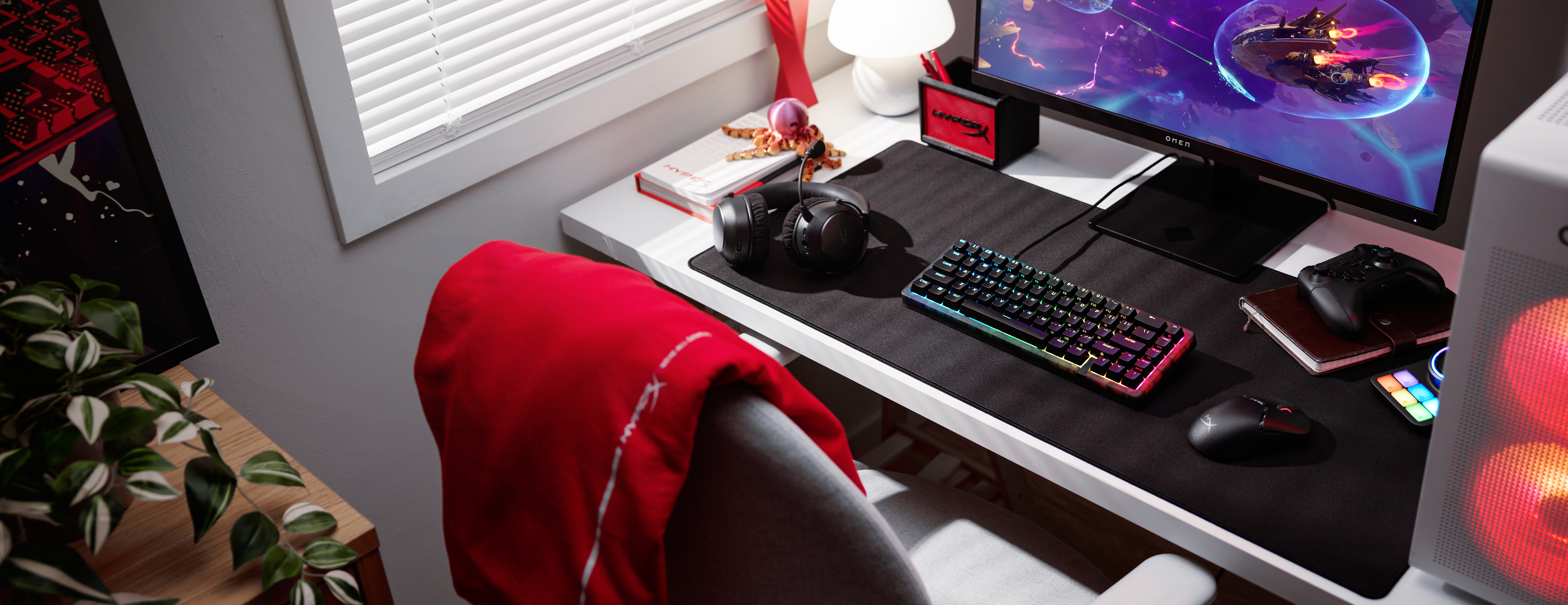 Gaming bureau met toetsenbord, muis, koptelefoon en monitor.