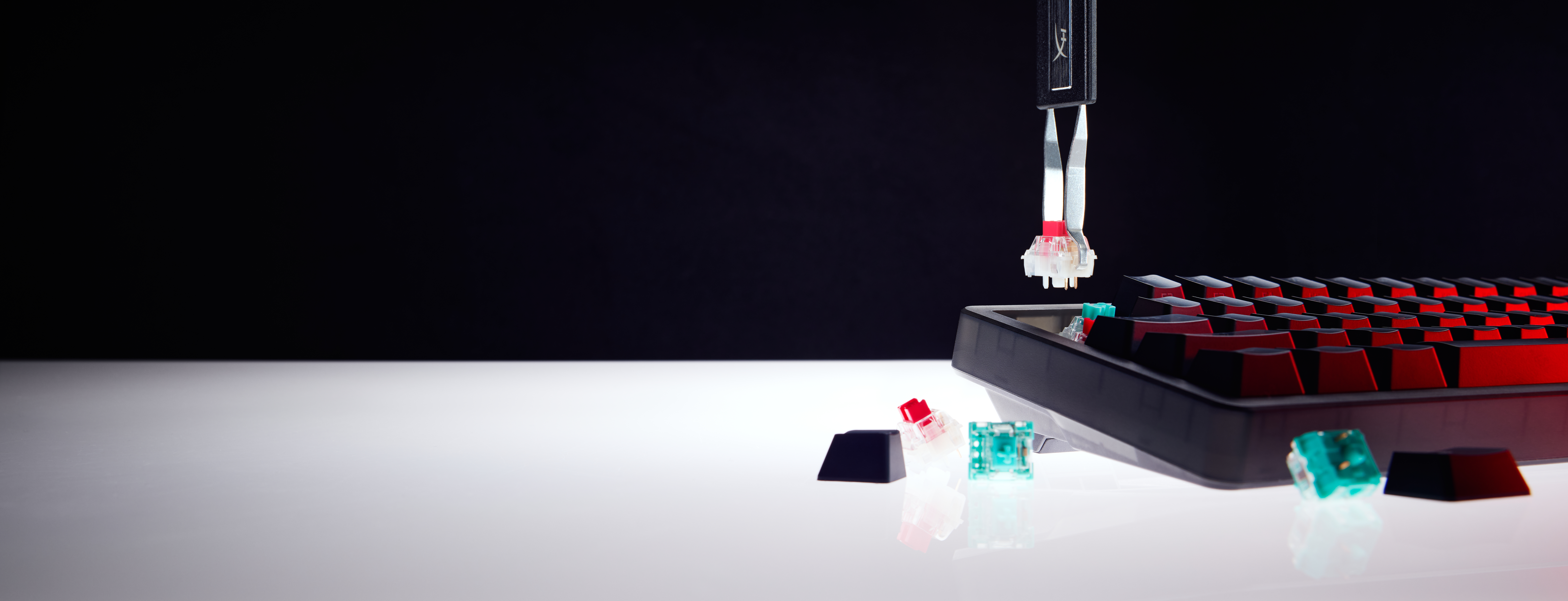 Een keycap puller verwijdert een rode switch cap van een toetsenbord.