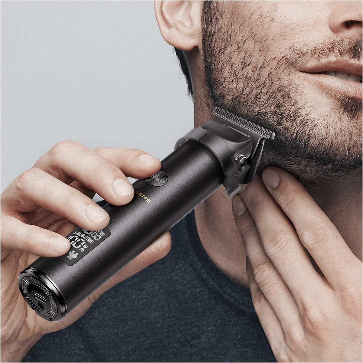 Mężczyzna przycina brodę czarną maszynką, wyświetla poziom baterii.