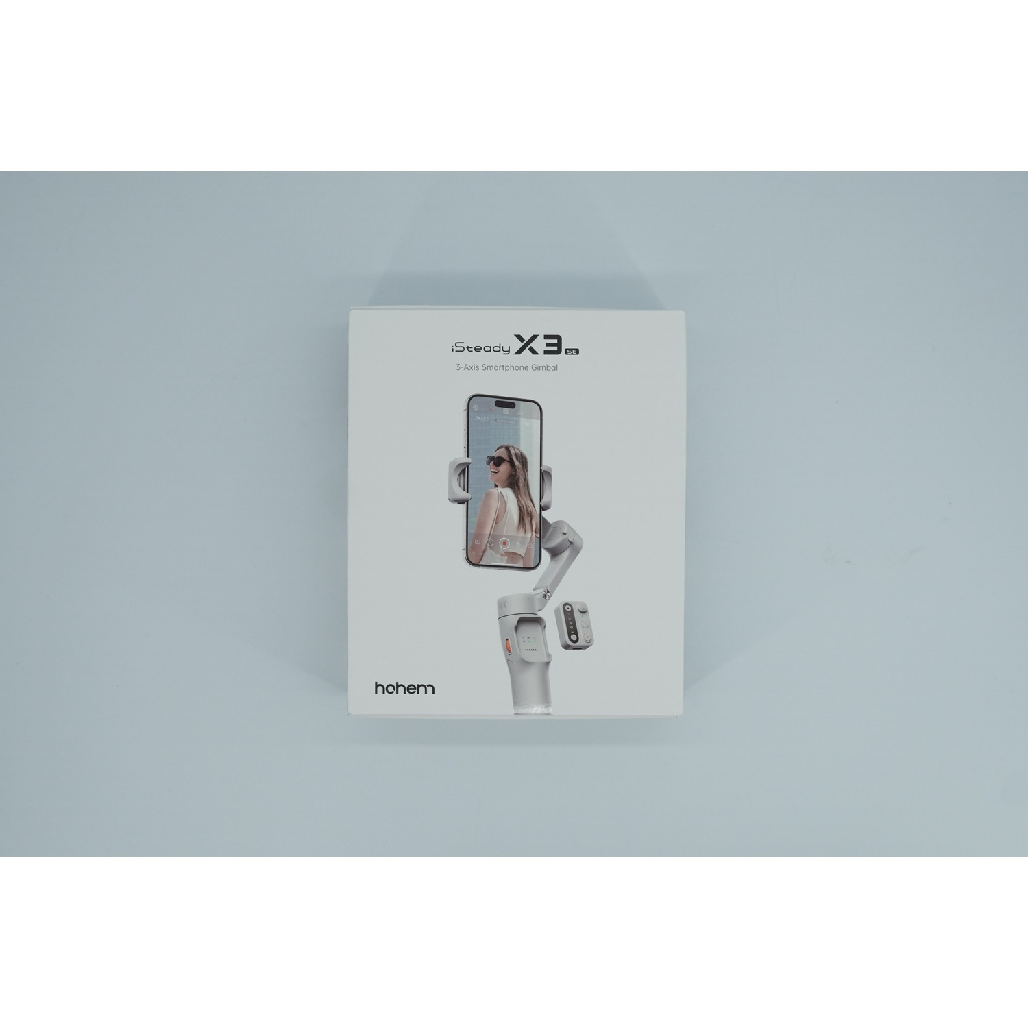 Scatola di un gimbal bianco con schermo smartphone che mostra una donna.