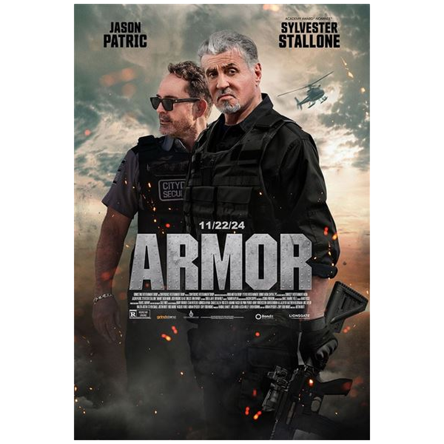 Deux hommes en tenue tactique se tiennent avec un hélicoptère en arrière-plan. Titre : ARMOR.