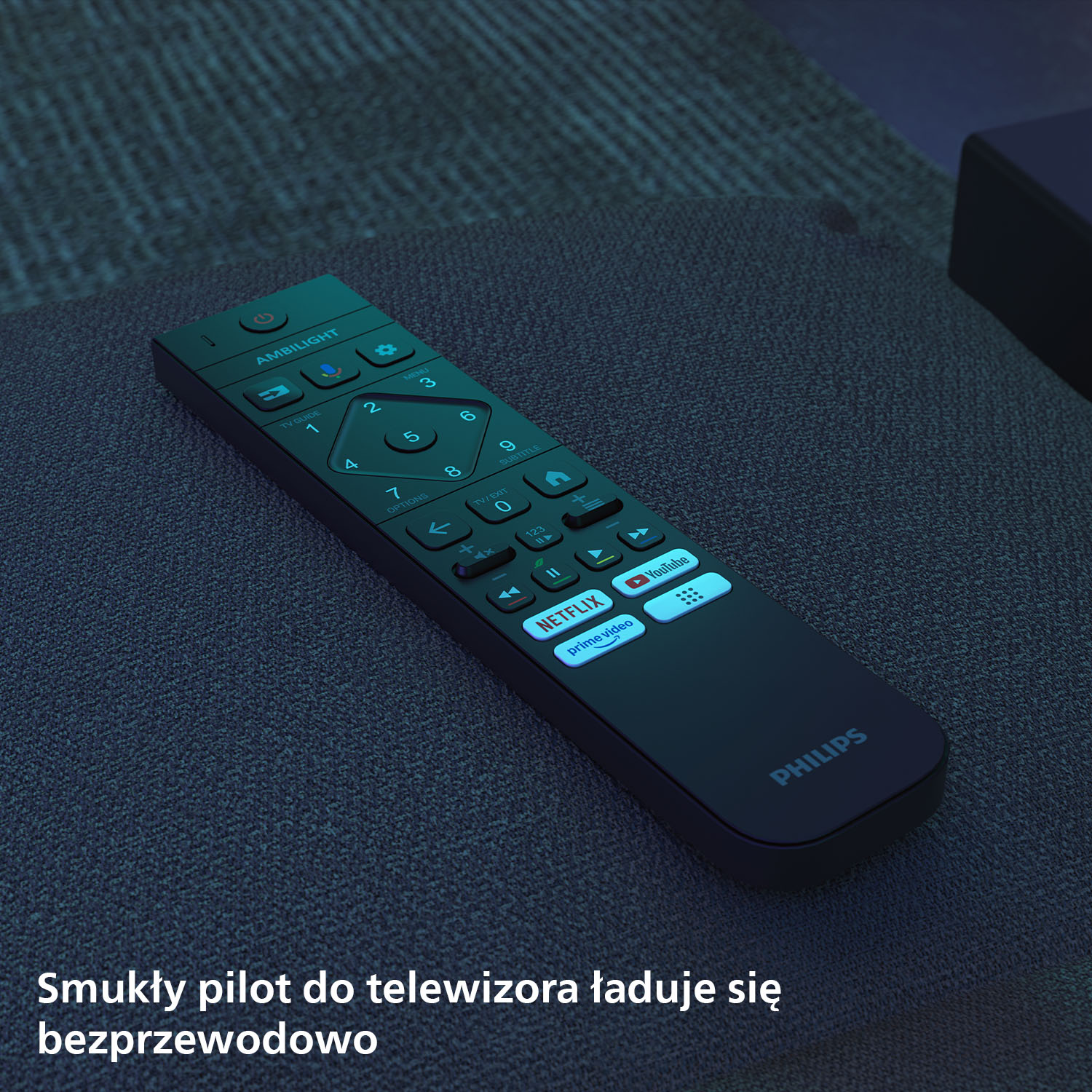 Czarny pilot Philips TV z Ambilight i przyciskami aplikacji na ciemnym materiale.