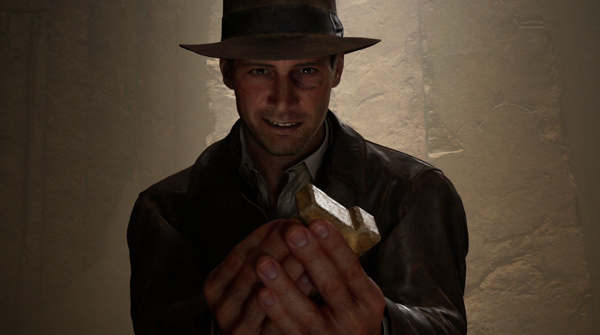 Ein Mann mit Hut hält ein goldenes Objekt in Händen.