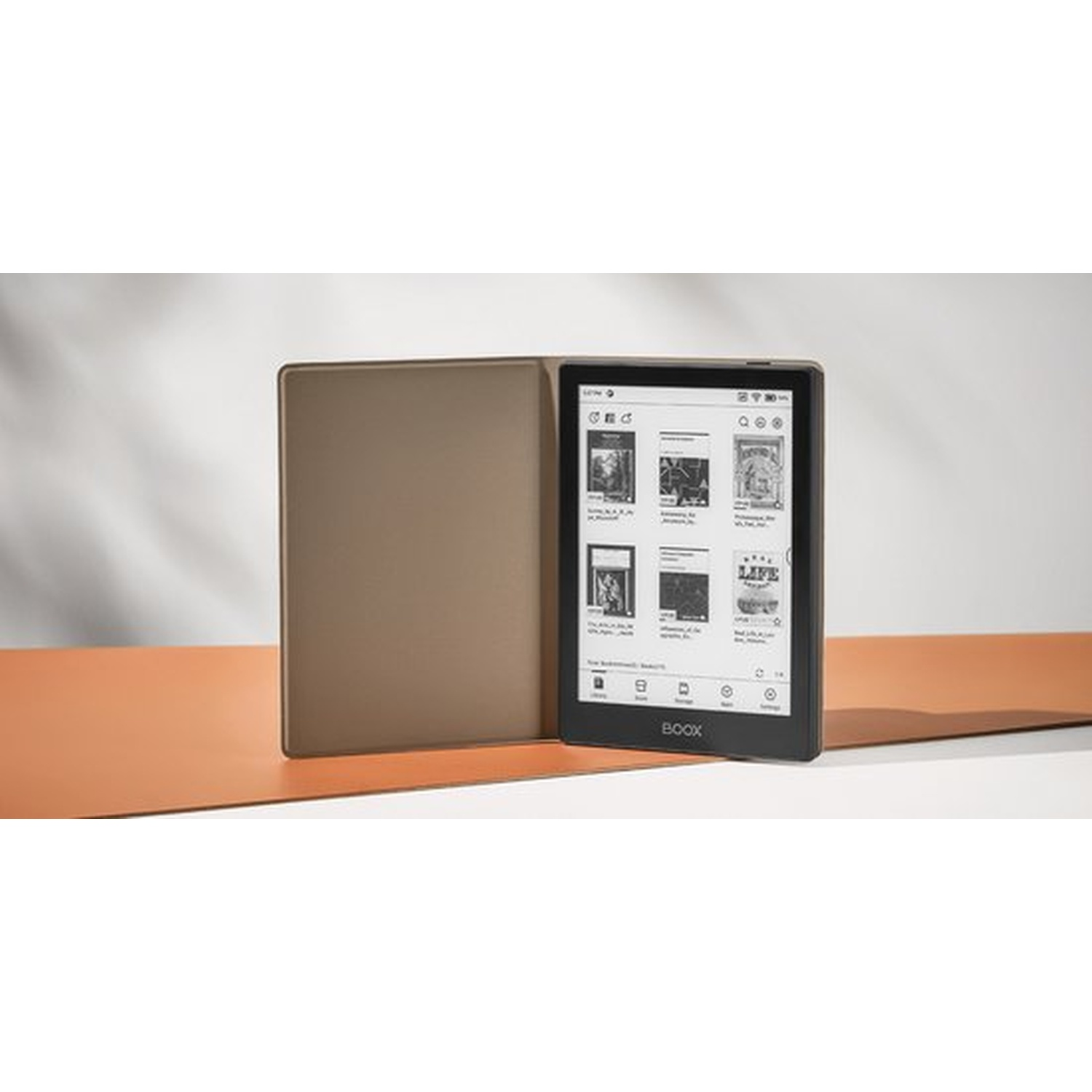 Een open e-reader met bruine hoes rust op een tweekleurig oppervlak.