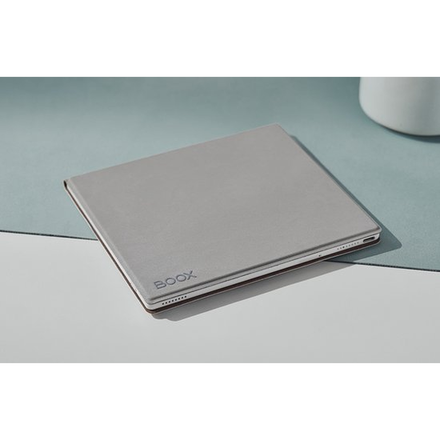Un liseuse électronique grise avec logo BOOX repose sur une surface claire.