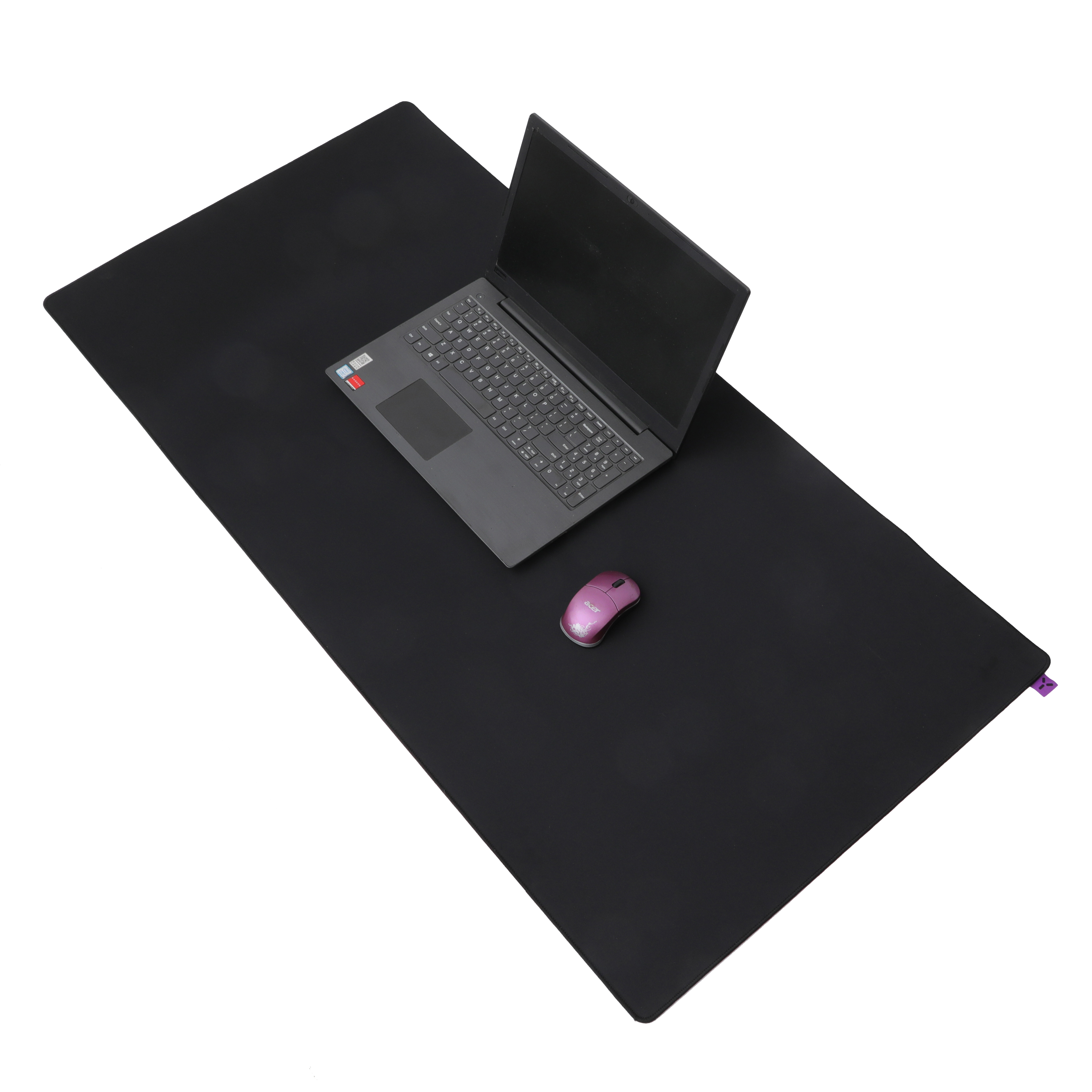 Czarny laptop i różowa mysz leżą na czarnej podkładce pod mysz.