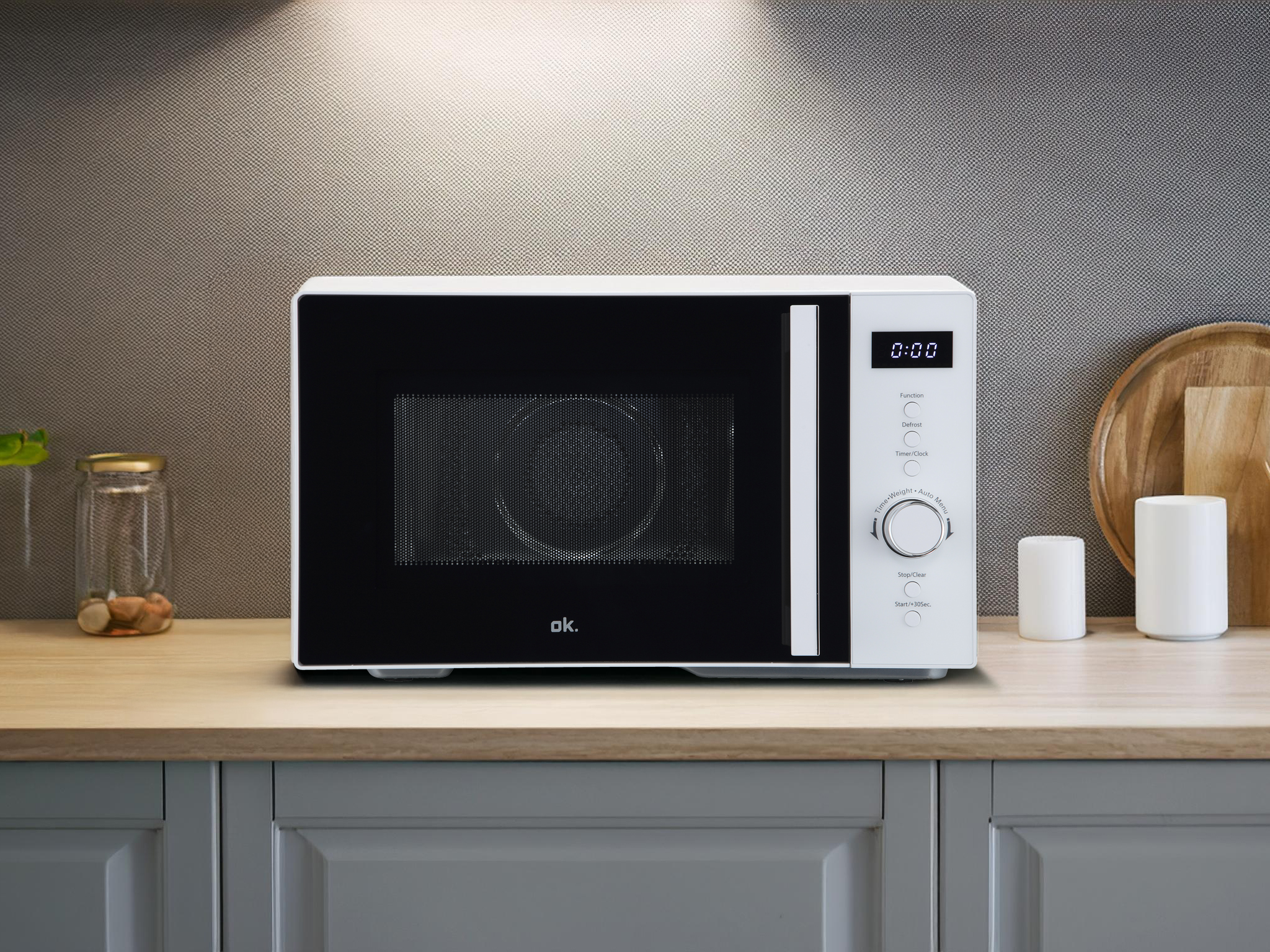 Biała mikrofalówka z czarnymi drzwiami stoi na blacie.