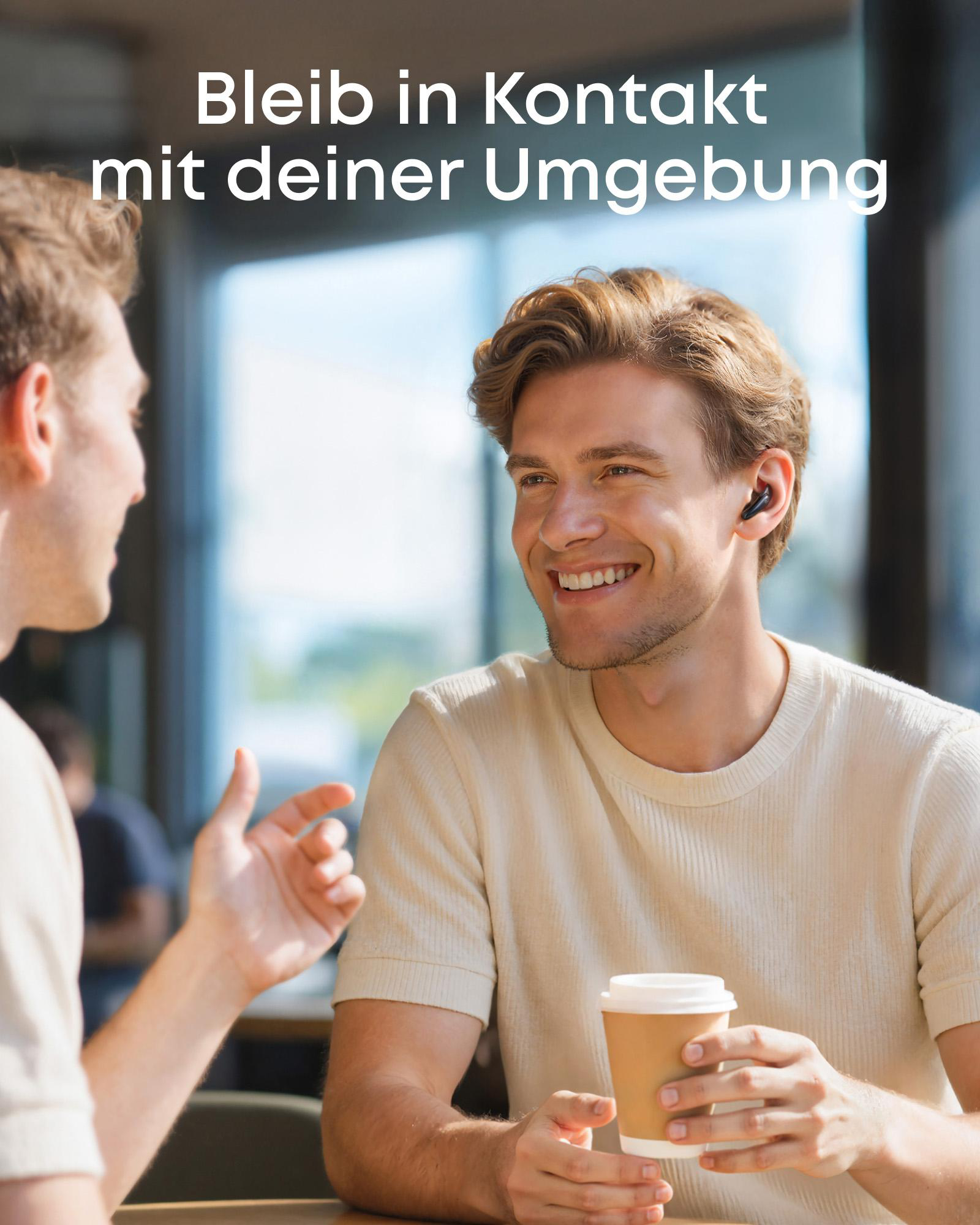 Zwei Männer unterhalten sich in einem Café. Einer trinkt Kaffee.