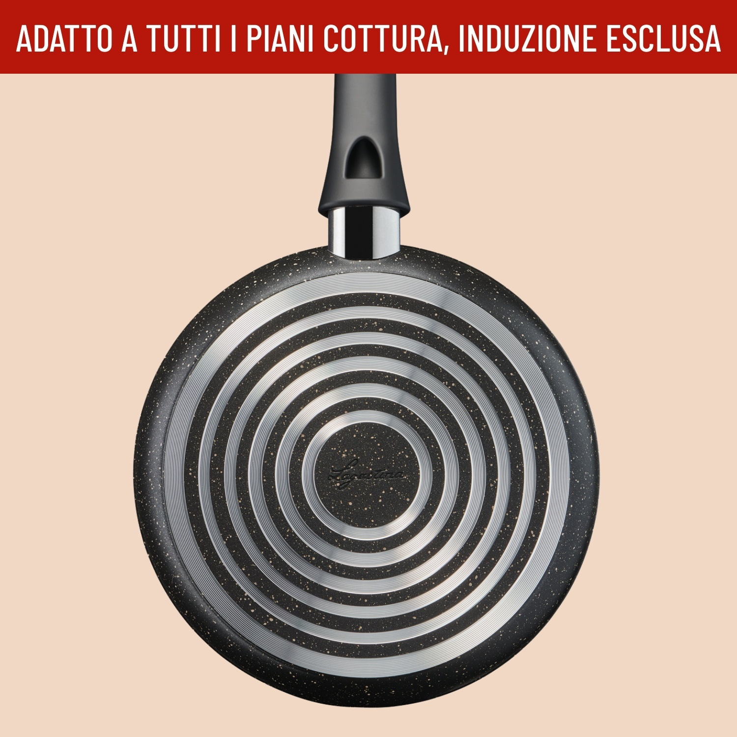 Fondo di una padella nera con anelli concentrici argentati su sfondo beige.