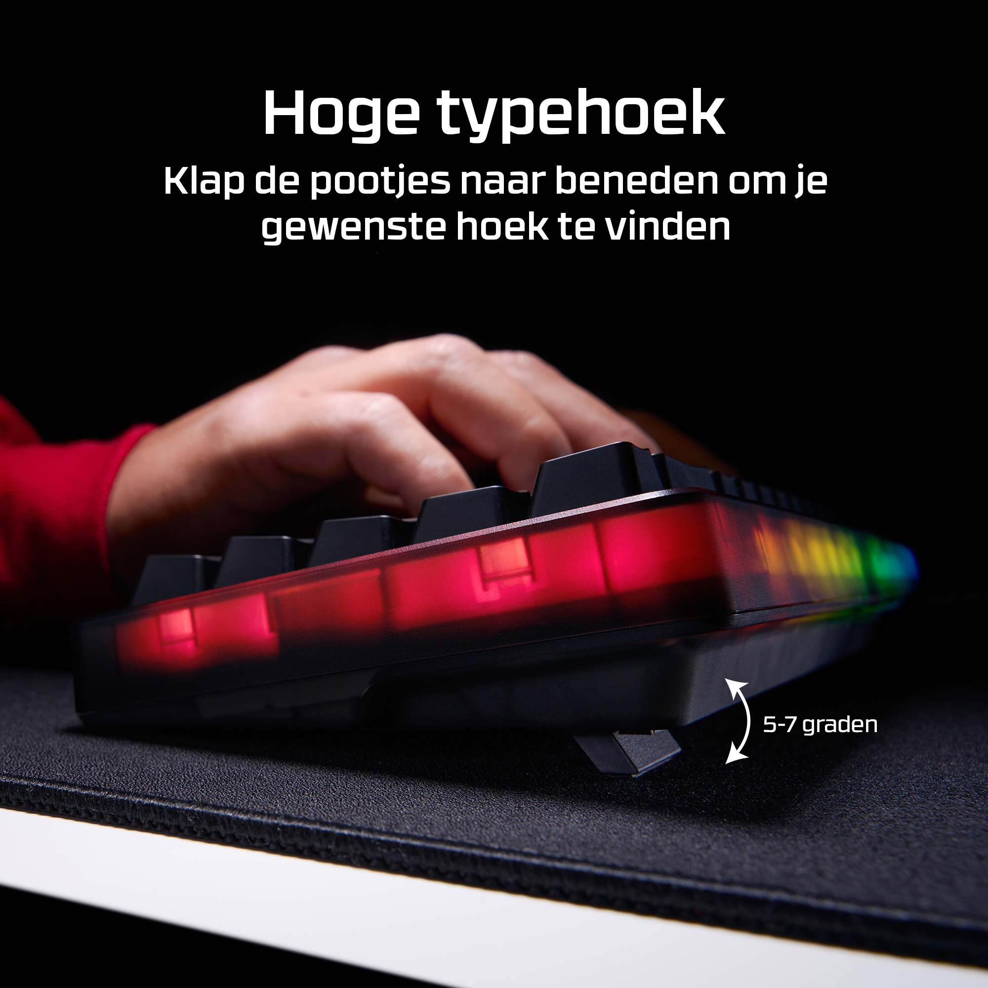 Een hand typt op een toetsenbord met RGB-verlichting en uitklapbare pootjes.