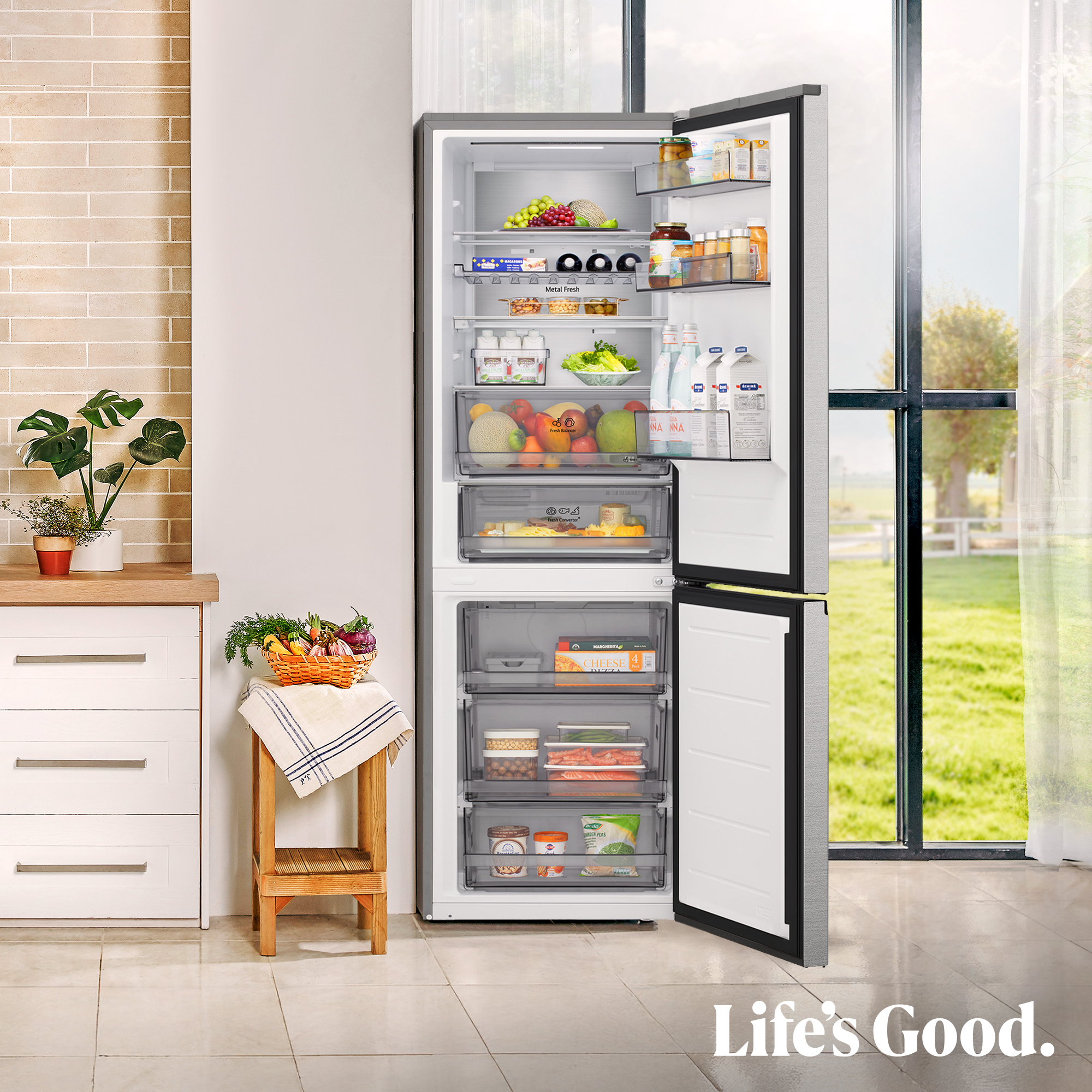 Un refrigerador abierto con alimentos y vista a un jardín.