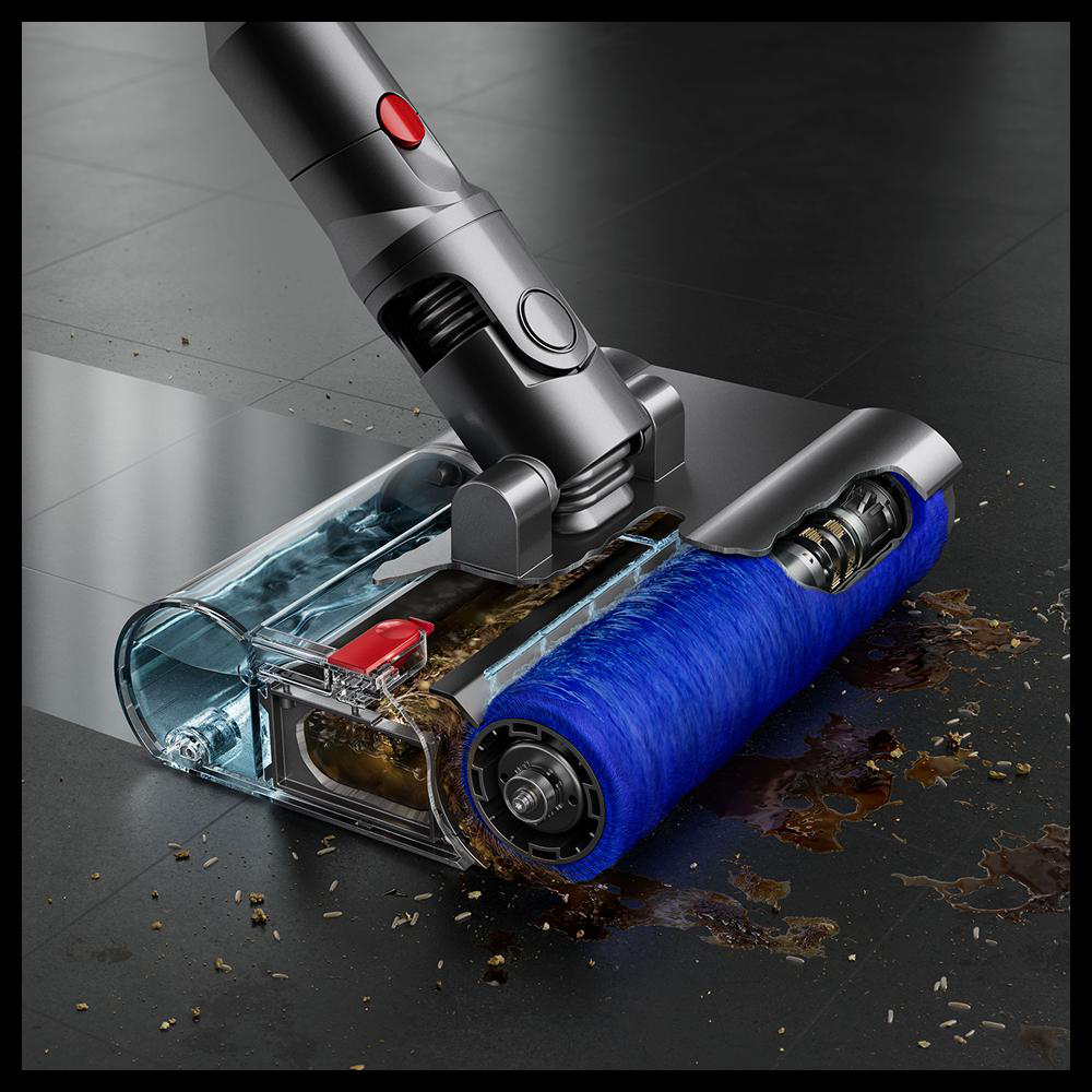 Ein Staubsaugerkopf reinigt nassen Schmutz von einem dunklen Boden.