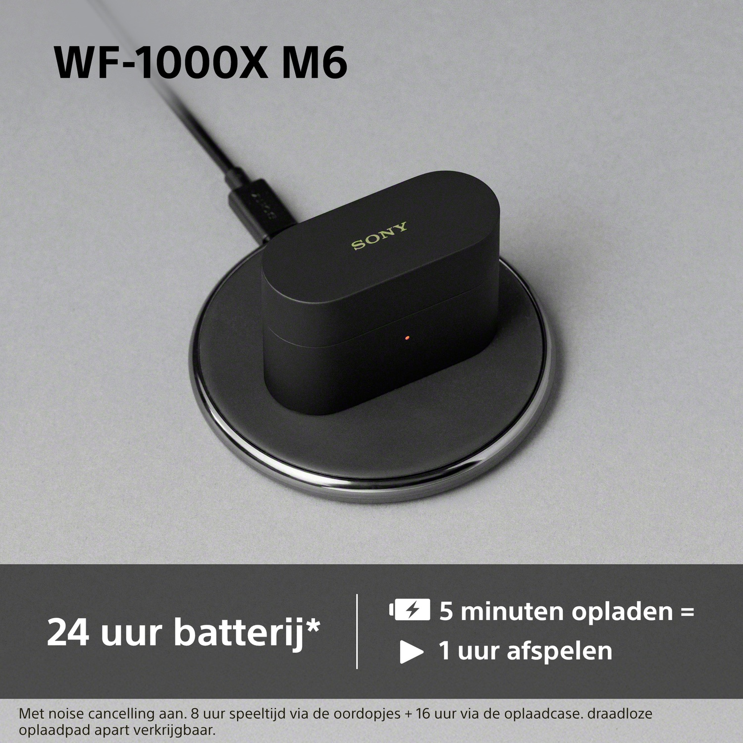 Écouteurs Sony WF-1000X M6 en charge sur socle sans fil avec câble.