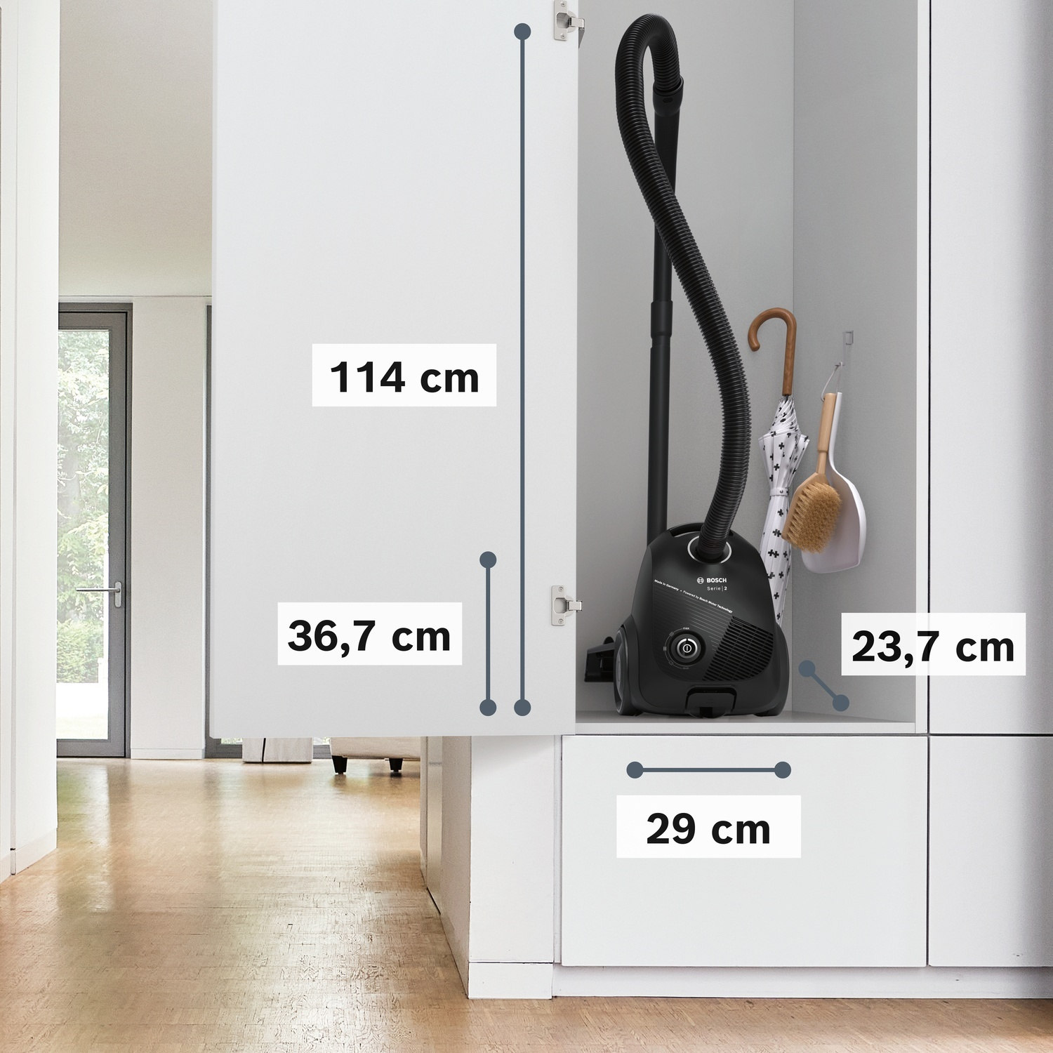 Aspirapolvere Bosch nero con accessori in un mobile bianco, dimensioni indicate.