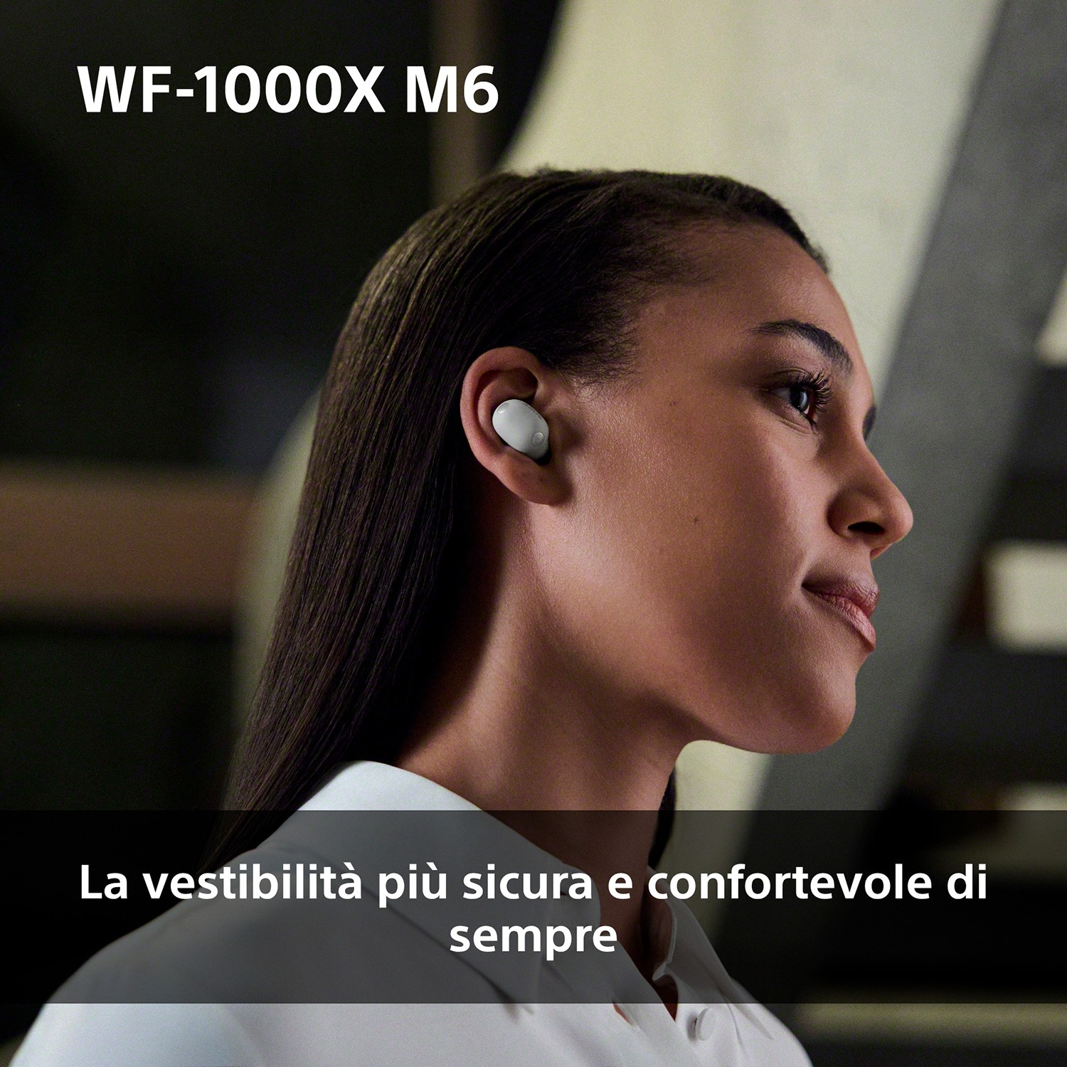 Una donna indossa un auricolare bianco nell'orecchio destro. Testo: WF-1000X M6.