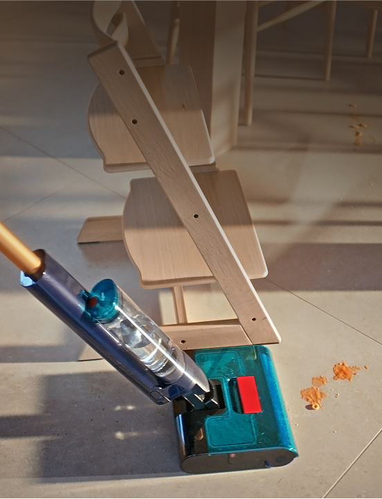 Odkurzacz czyści pomarańczowe plamy na jasnej podłodze z płytek obok drewnianego krzesełka do karmienia.