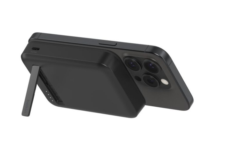 Beyaz arka plan üzerinde stantlı siyah pil paketine takılı siyah iPhone.