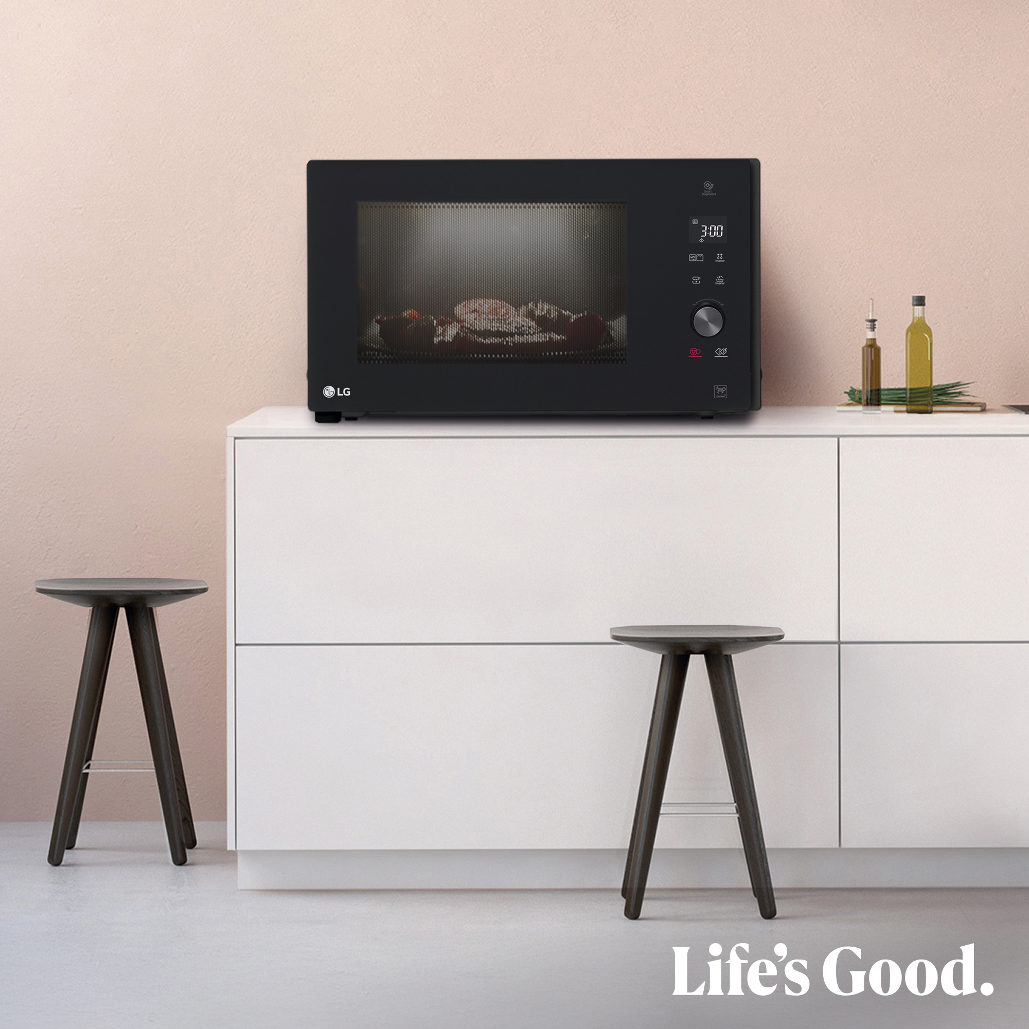 Un microondas LG negro con comida dentro está sobre un mueble blanco.