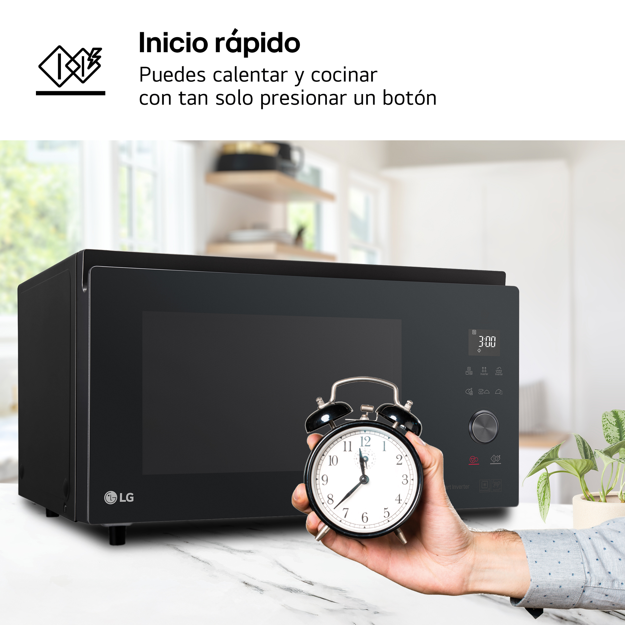 Un hombre sostiene un despertador frente a un microondas LG negro en una cocina.