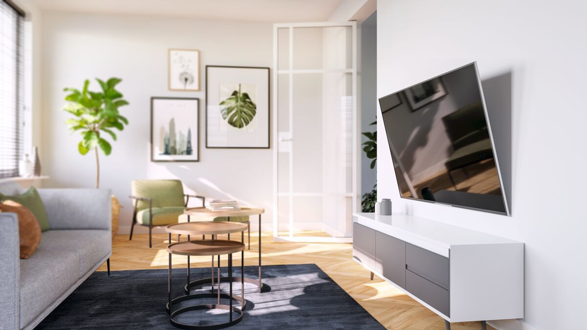 Jasny salon z sofą, fotelem, stolikami kawowymi i telewizorem na ścianie.