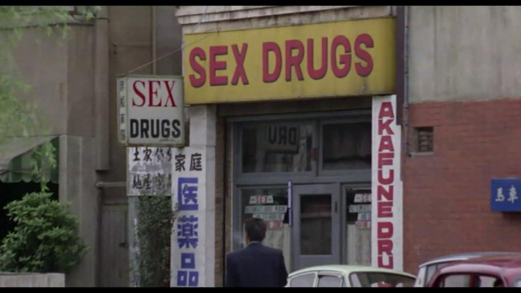 Ein Mann geht auf ein Geschäft zu, das „SEX DRUGS“ heißt.