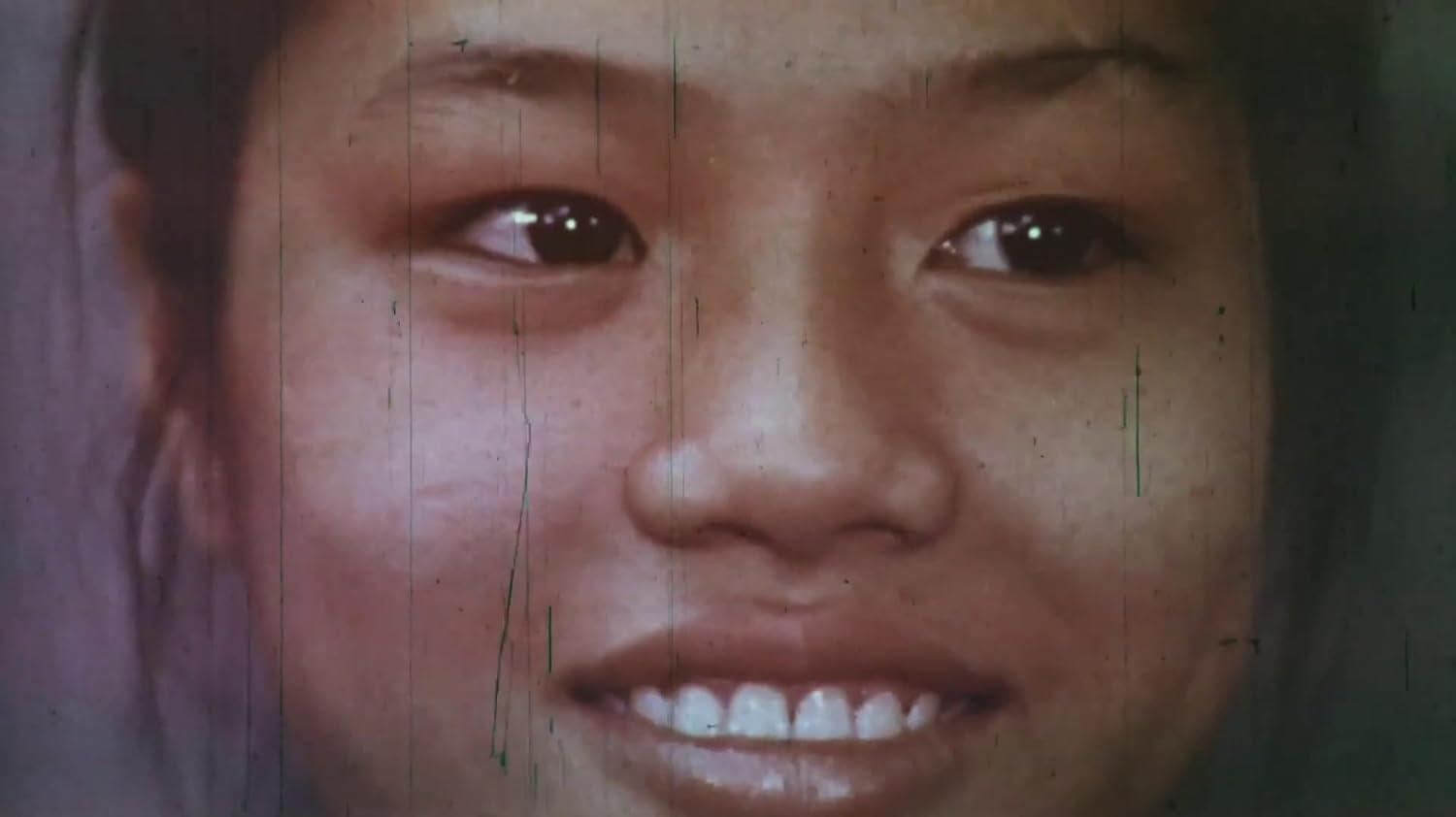 Nahaufnahme eines lächelnden asiatischen Mädchens mit dunklen Haaren und braunen Augen.