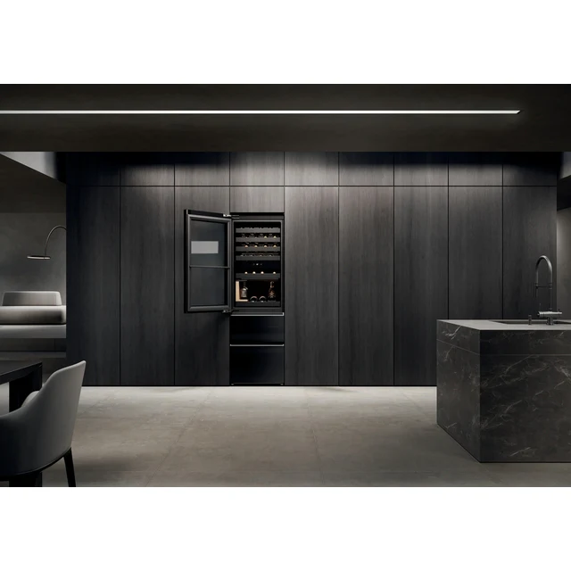 Vinoteca moderna oscura con puerta abierta, llena de botellas, en una cocina.