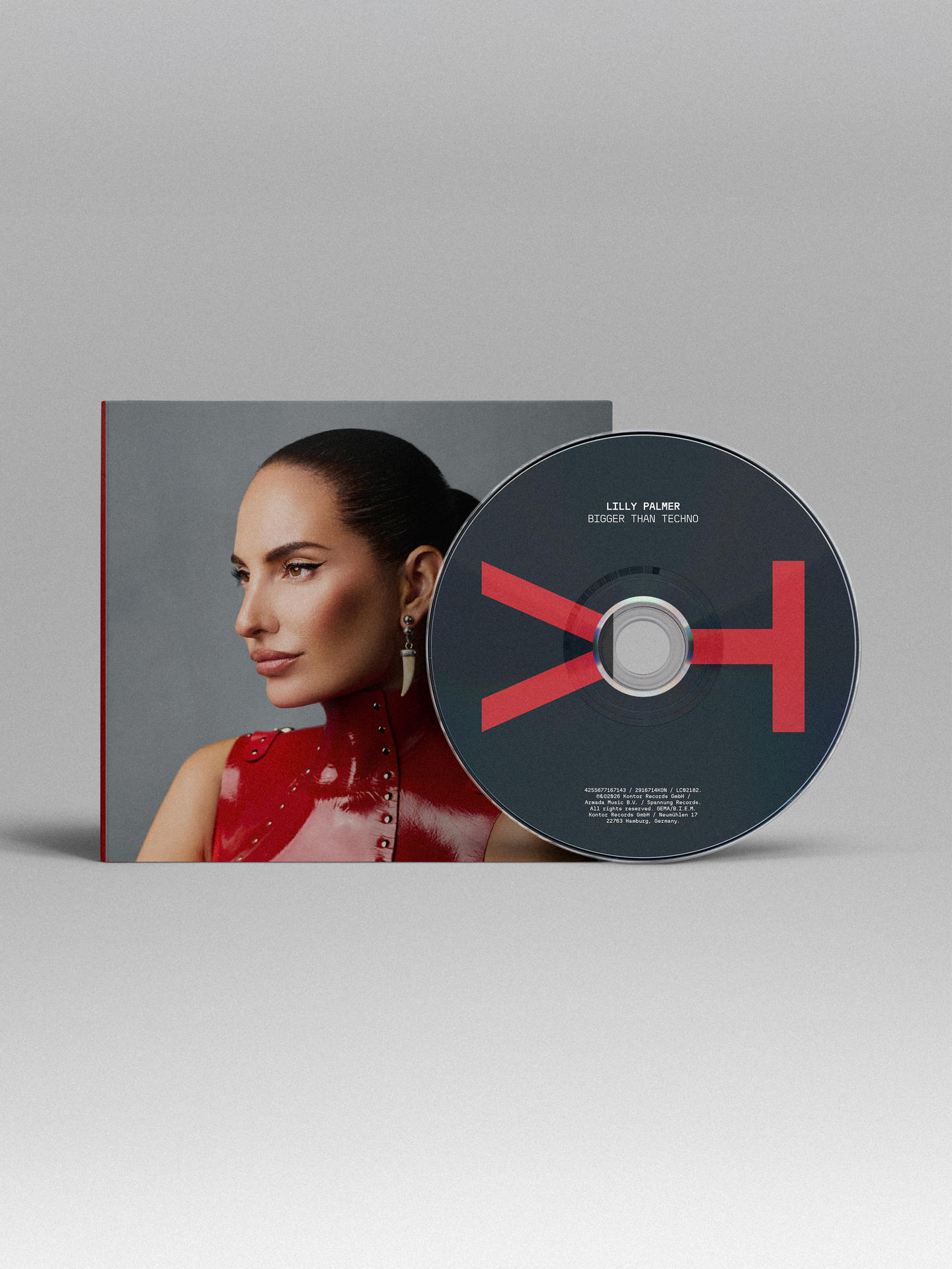 Lilly Palmer im roten Lack-Oberteil neben einer CD mit rotem Logo.