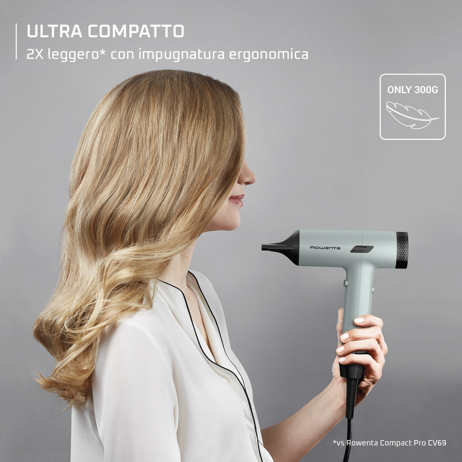 Una donna tiene un asciugacapelli Rowenta grigio chiaro. Solo 300g.