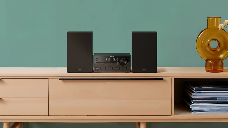 Egy fekete Hi-Fi rendszer két hangszóróval és CD-lejátszóval fa szekrényen.