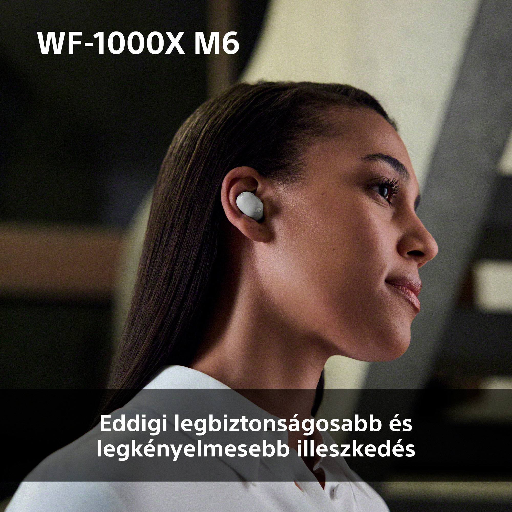 Nő fehér fülhallgatóval a jobb fülében, WF-1000X M6.