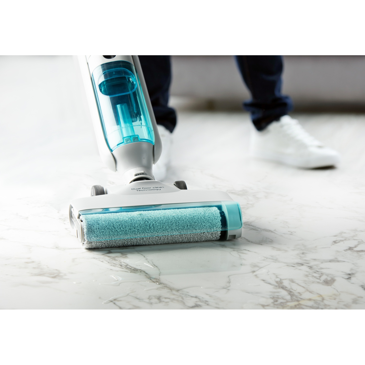 Un aspirateur eau et poussière avec réservoir bleu nettoie un sol en marbre.