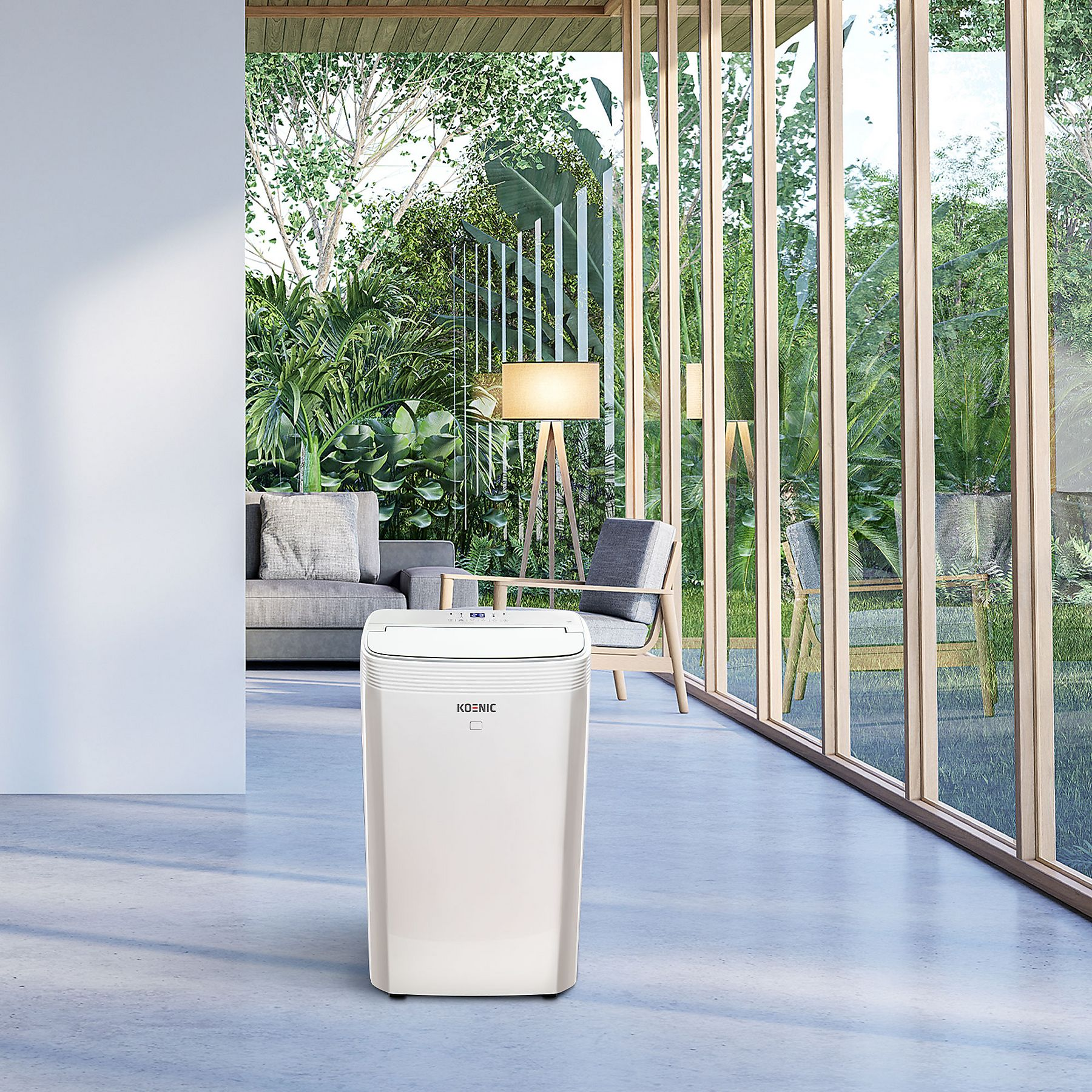 Biały klimatyzator w jasnym pomieszczeniu z dużymi oknami i zielenią.