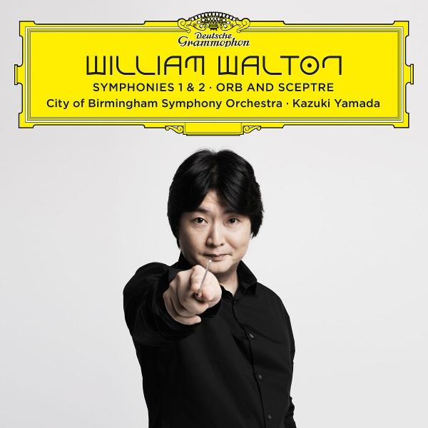 Dirigent Kazuki Yamada zeigt nach vorne. Oben gelbes Deutsche Grammophon Logo.