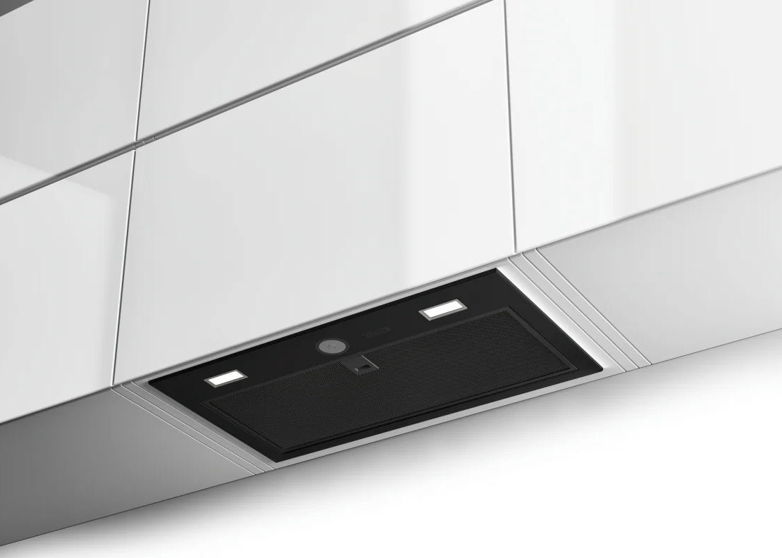 Czarny okap z oświetleniem pod białymi szafkami.