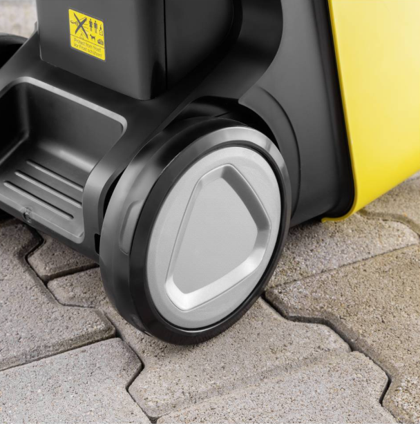 Zbliżenie żółto-czarnej maszyny z kołem na bruku.