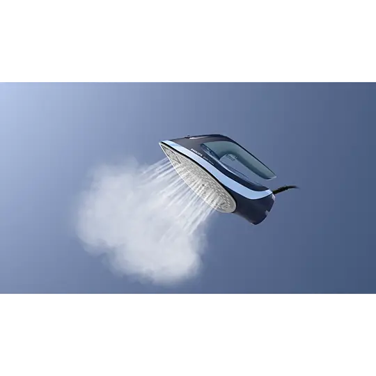 Ciemne żelazko emituje parę na tle niebieskiego nieba.