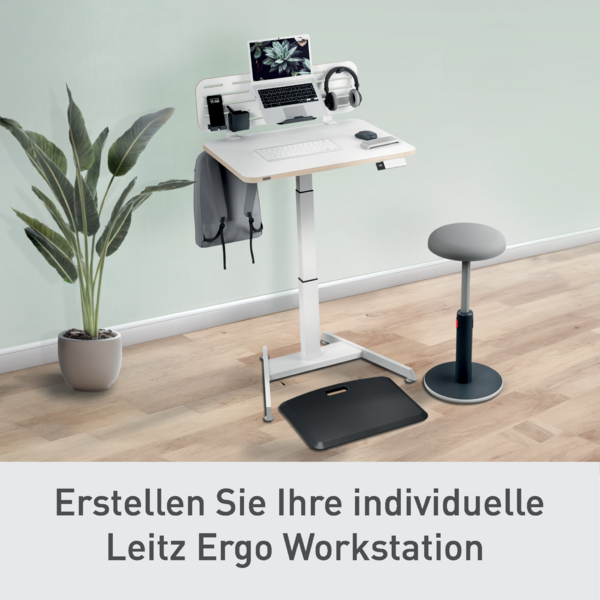 Ein höhenverstellbarer Schreibtisch mit Laptop, Kopfhörern und einem Hocker.