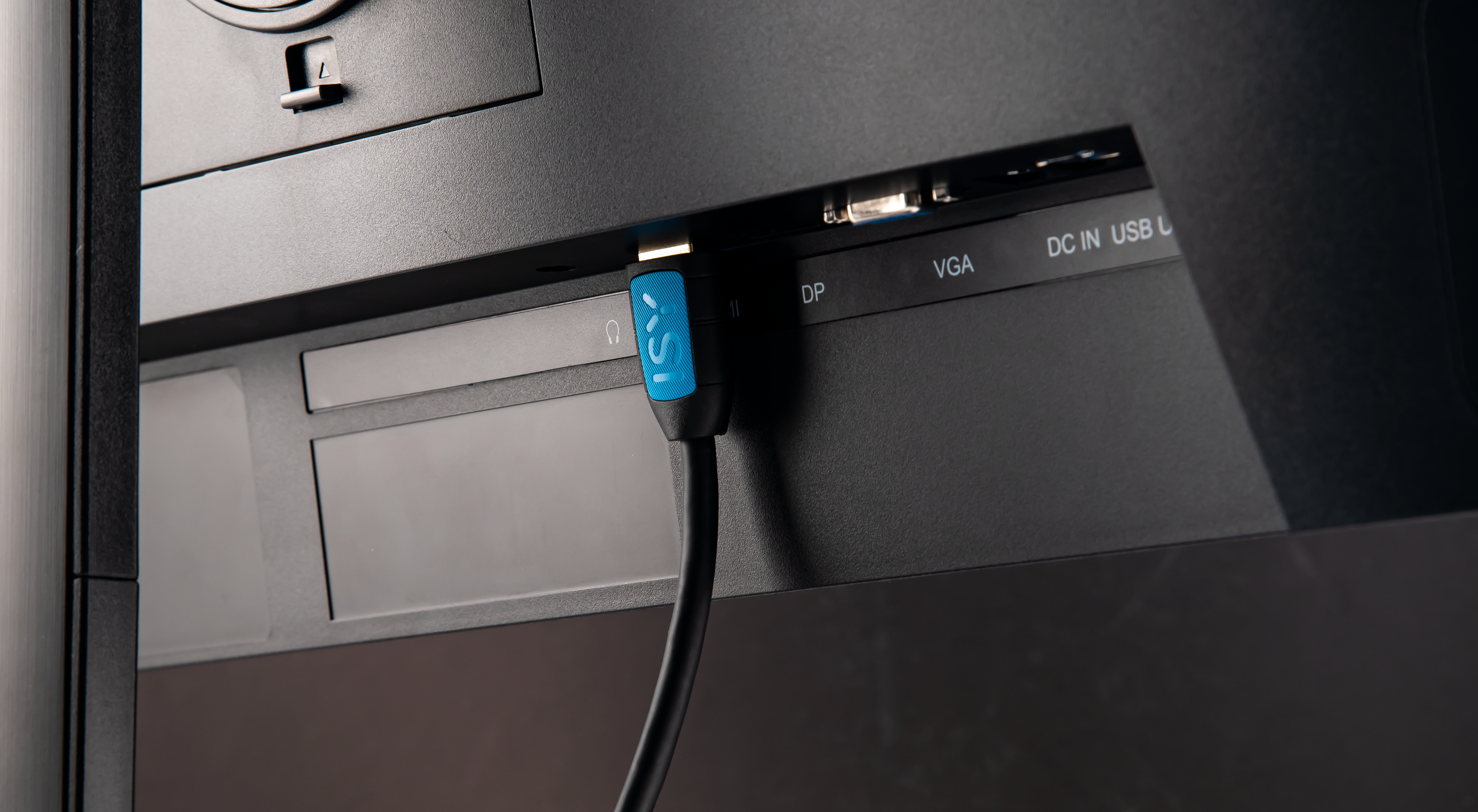 Niebieska wtyczka z logo włożona do czarnego portu.