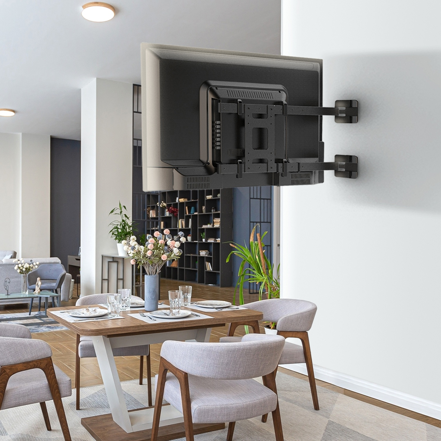 Un TV a parete è sopra un tavolo da pranzo apparecchiato per quattro in una stanza moderna.
