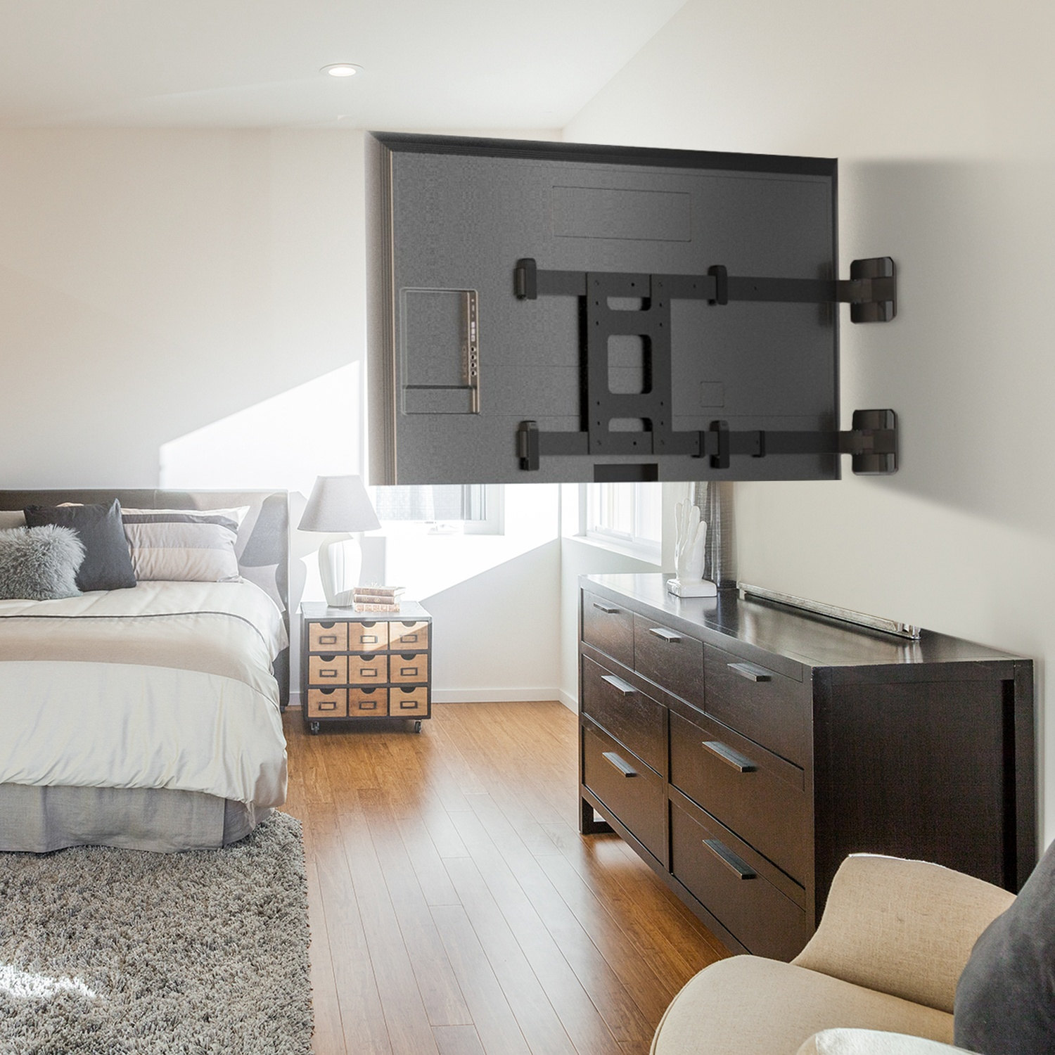 Una camera da letto con TV a parete, letto, comodino e cassettiera.